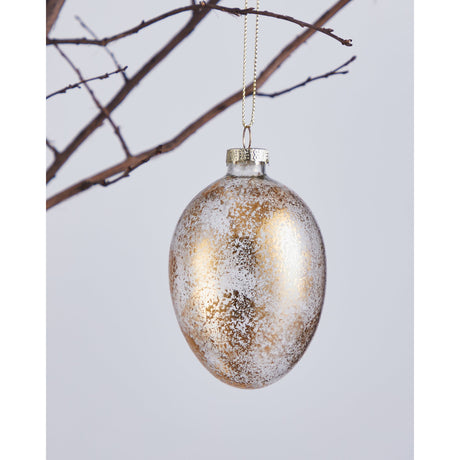 Fintry Glass Decorative Egg in clear glass with gold and white speckled finish, gold cap and cord loop, hanging from a branch against a plain light background.