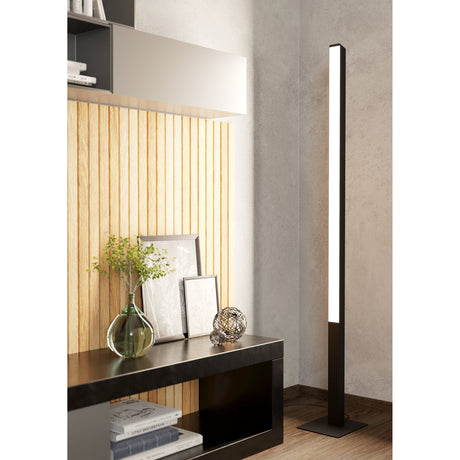 Flanvorne Smart Colour Changing LED Floor Lamp in black, a slim square aluminium and steel column with front diffuser, shown illuminated in a living room beside a console table.