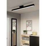 Flanvorne Smart LED flush ceiling light in black, a slim linear bar with white diffuser and central mount, shown illuminated on a hallway ceiling above a mirror and console.