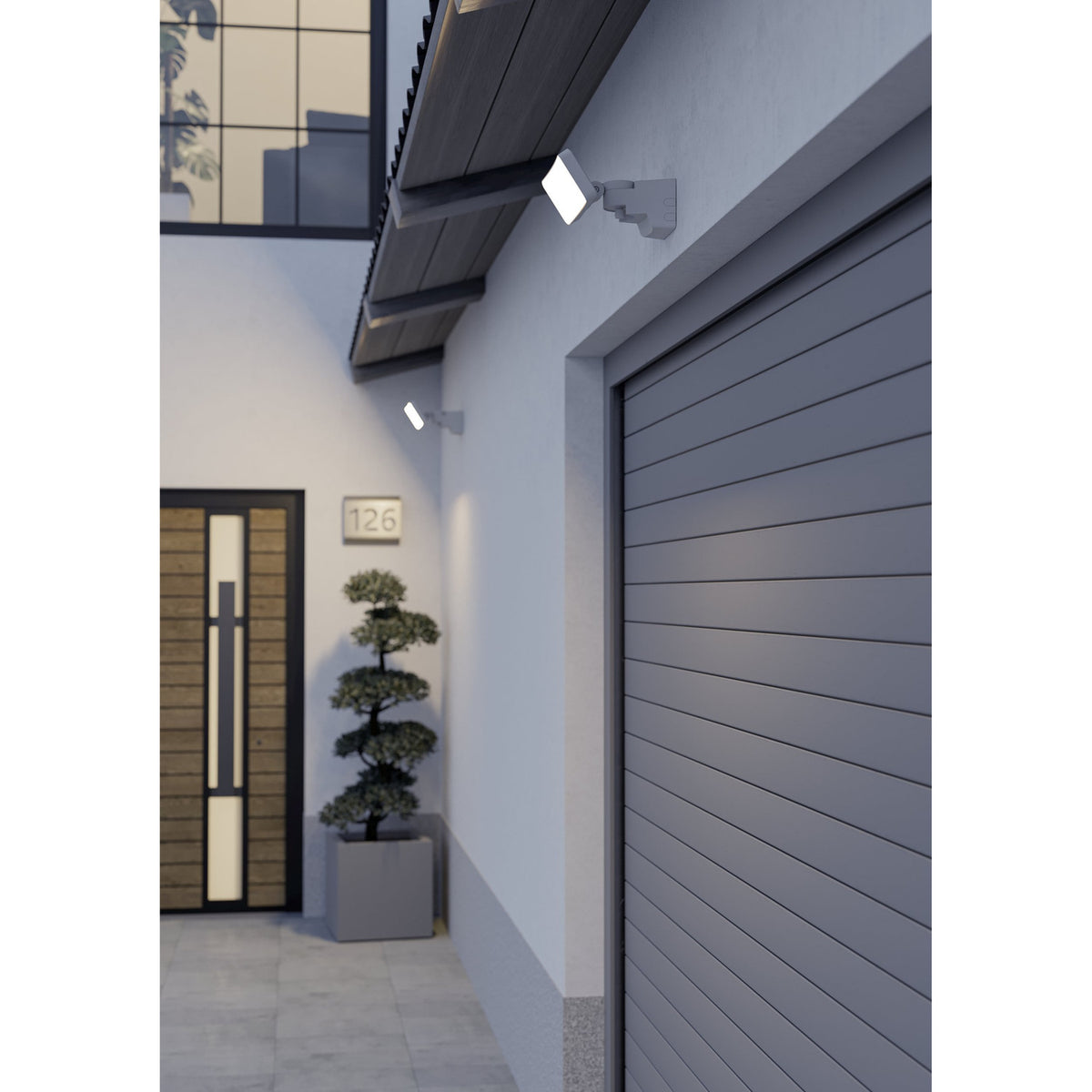 Flenvenne LED Flood Light in white mounted above a garage door and near a glazed entrance, showing the rectangular panel on an adjustable bracket in an outdoor residential setting.