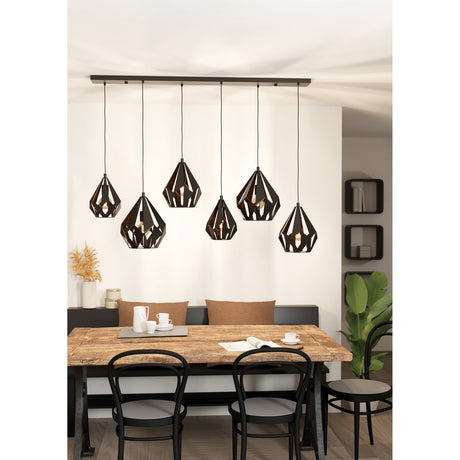 Flermanne 6 Light Linear Pendant Light in black and copper steel, six faceted cage shades at staggered heights on a long ceiling bar, shown above a dining table.