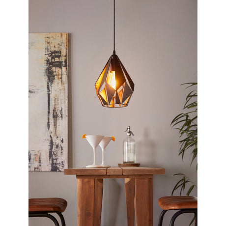 Flermanne Pendant Light 20.5cm in black and copper steel, faceted teardrop shade with cut-outs, lit above a wooden table in a dining area.