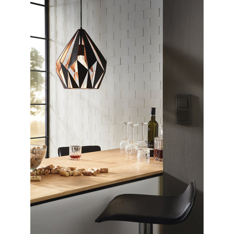 Flermanne Pendant Light 31cm in black and copper, geometric faceted steel shade on a black cord, hung above a kitchen bar with wine glasses and bottles below.