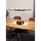 Flimarne black LED pendant light with three interlinked oval loops on fine wires, shown above a wooden dining table with black chairs.