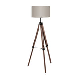 Flivelle Floor Lamp tripod with three walnut wood legs, black steel joints, and a taupe fabric drum shade, shown on a plain white background.