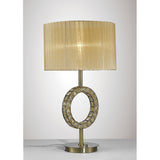 The Florence Round 1 Light Crystal Table Lamp features a brass base, a decorative ring with crystal accents, and a large pleated cream fabric shade. It is displayed on a flat white surface against a light background.