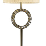 The Florence Round 1 Light Crystal Floor Lamp in brass features a circular decorative metal ring, crystal accents, and a cream shade. This dimmable lamp brings elegance and versatility to any space.