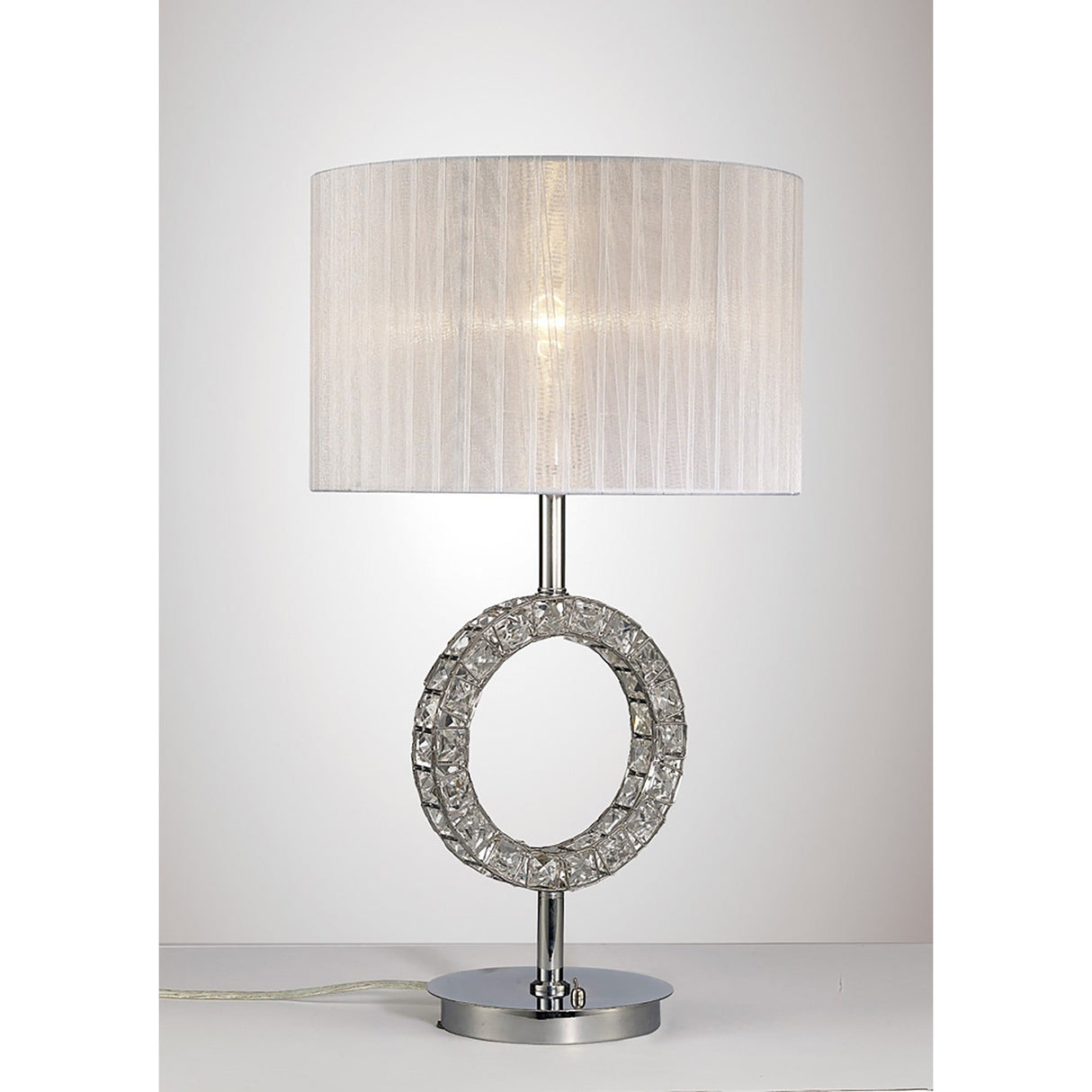 The Florence Round 1 Light Crystal Table Lamp features a modern chrome finish, a round base with an open circular accent, and a white cylindrical shade, displayed on a flat surface against a plain background.