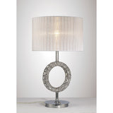 The Florence Round 1 Light Crystal Table Lamp features a modern chrome finish, a round base with an open circular accent, and a white cylindrical shade, displayed on a flat surface against a plain background.