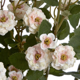 Close-up of Hill Interiors Cream Wild Meadow Rose faux stem showing ruffled cream and pink petals with yellow centres among textured green leaves.