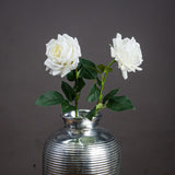 Large white garden rose faux stems by Hill Interiors in a ribbed silver vase, showing full blooms and green leaves against a grey backdrop.