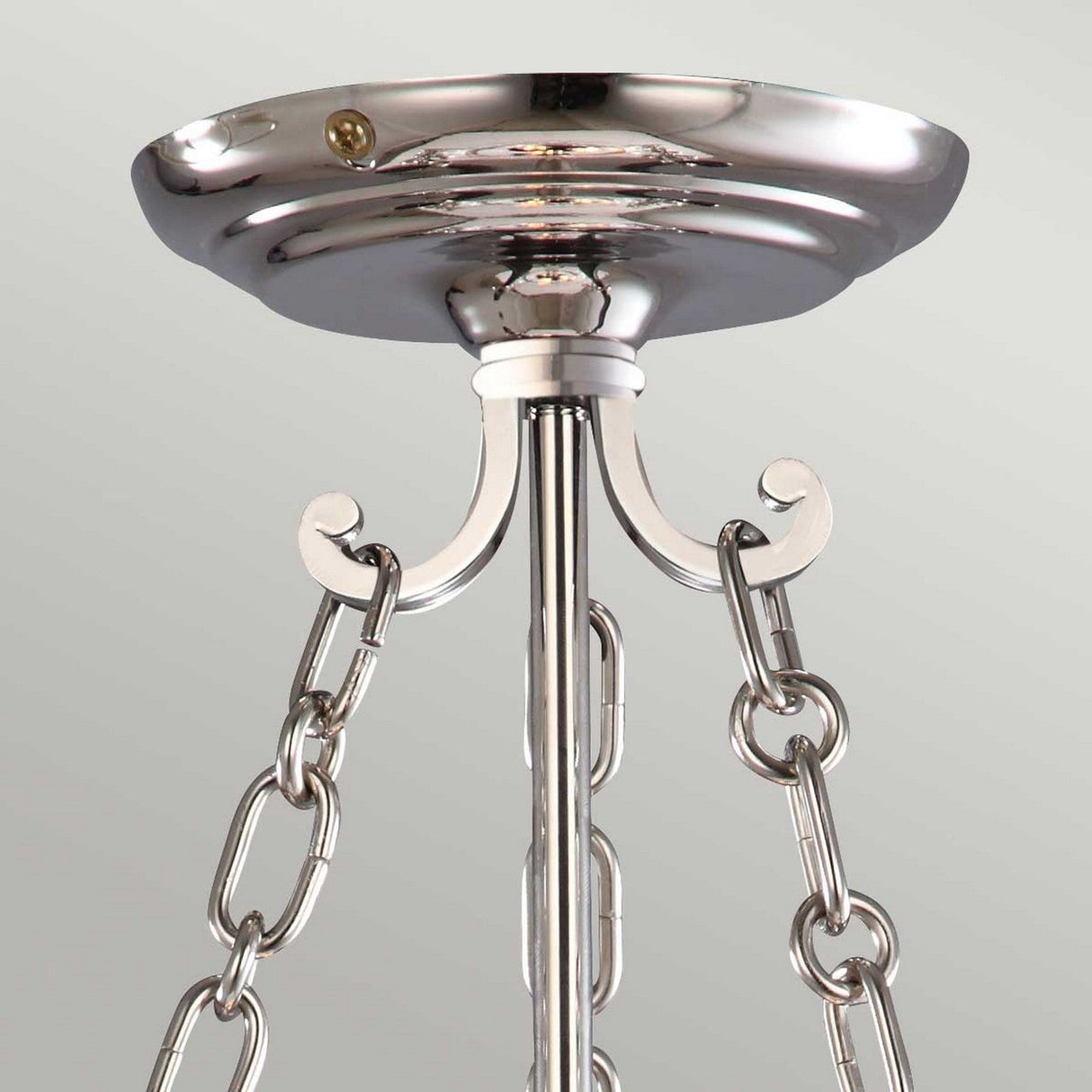 This close-up showcases the elegant design of the Finsbury Park 3 Light Small Chandelier in polished nickel. The ceiling fitting features a central pole with three chains, ideal for supporting the chandelier. A subtle, light backdrop enhances its refined craftsmanship.