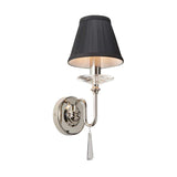 The Finsbury Park 1 Light Wall Light - Polished Nickel features a sleek metallic finish complemented by a black lampshade. Its underlay of hand-cut glass droplets and a teardrop-shaped pendant adds an elegant touch, while the polished nickel base and arm contribute to its contemporary style.