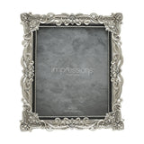 Rectangular resin photo frame in silver with raised floral scrollwork and crystal accents at the corners, holding a grey sample print for 8x10in photos on a white background.