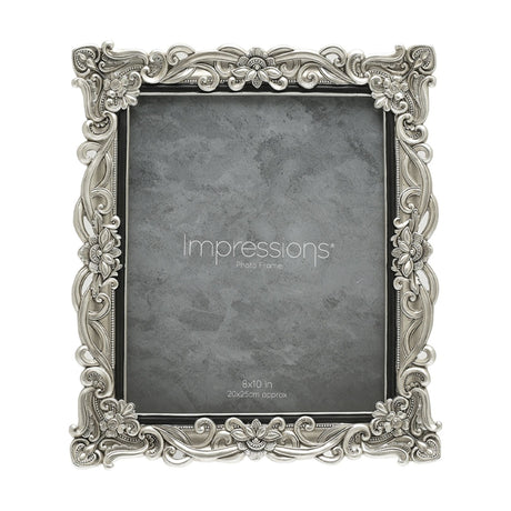 Rectangular resin photo frame in silver with raised floral scrollwork and crystal accents at the corners, holding a grey sample print for 8x10in photos on a white background.