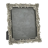 Antique-style rectangular photo frame in silver resin with raised floral scrollwork and crystal accents at the corners, a slim black inner edge, and a grey insert, shown on a white background.