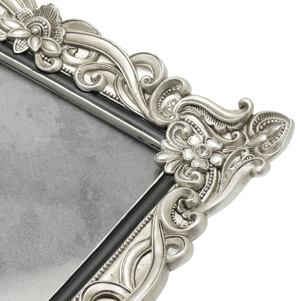 Close-up of the Antique Floral Resin Photo Frame 10 x 8in in silver, showing raised scrollwork, crystal-set flower corners, and a slim black inner edge.