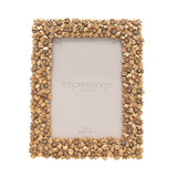 Rectangular resin photo frame with a raised floral border in gold finish, overlapping blossom details, shown on a plain white background with a 5x7 in insert.