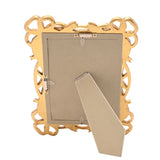 Back view of the gold resin Bowknot Design photo frame showing the fold-out easel stand and hanging hooks, set against a plain white background.