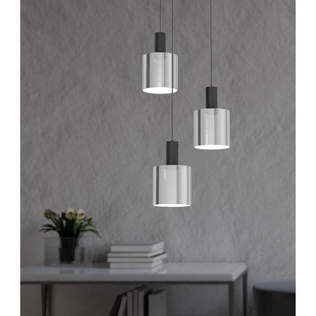 Fralvessa 3-light pendant with smoked glass cylinder shades and black fittings at staggered heights, shown against a grey textured wall above a console table.