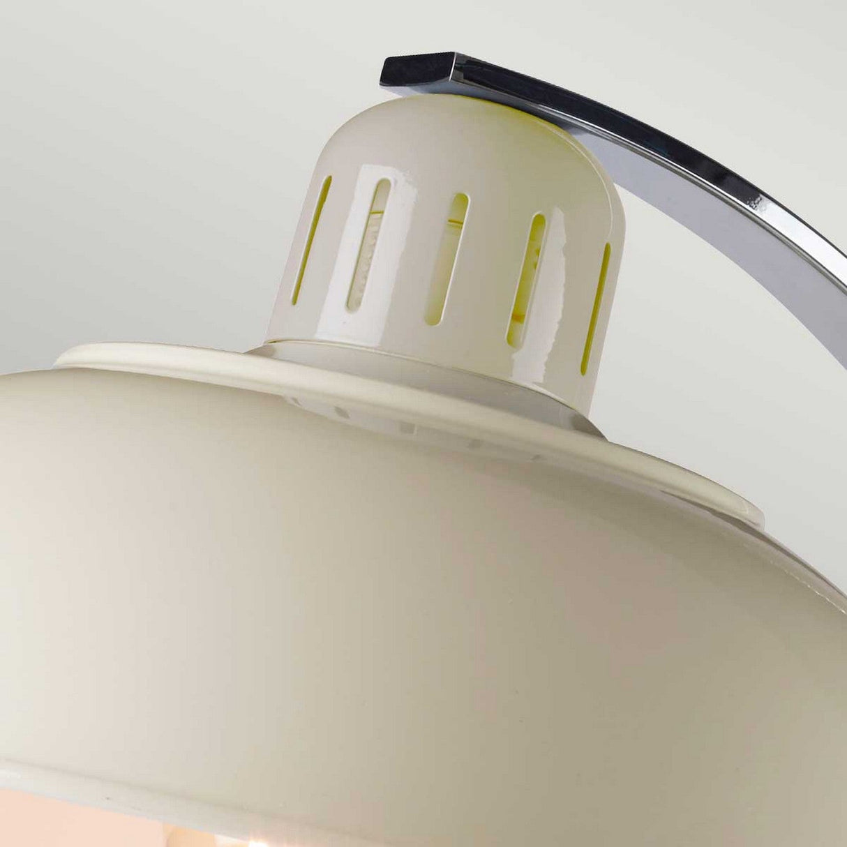 Close-up of the Franklin Desk Lamp - White, a modern interior marvel featuring a smooth, dome-shaped shade with metallic accents on top. The design includes slits around the upper part for task lighting and has a curved metal arm attached above. The background is light gray.