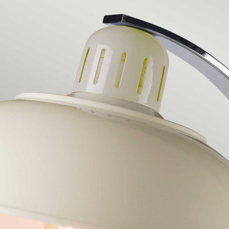 Close-up of the Franklin Desk Lamp - White, a modern interior marvel featuring a smooth, dome-shaped shade with metallic accents on top. The design includes slits around the upper part for task lighting and has a curved metal arm attached above. The background is light gray.