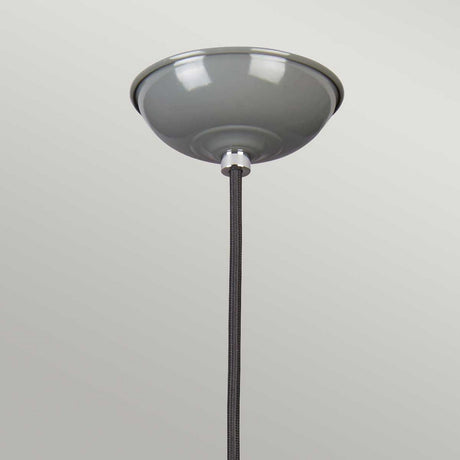 The Franklin Pendant Light - Grey showcases a dome-shaped ceiling mount in gray and a textured fabric cord, capturing the essence of retro diner style as it elegantly hangs against a simple light gray backdrop.