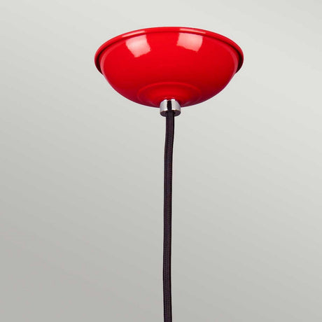 The bold Franklin Pendant Light- Red, hanging from a sleek black cord, stands out against the light gray background. Ideal for task lighting, it brings both style and functionality to any space.