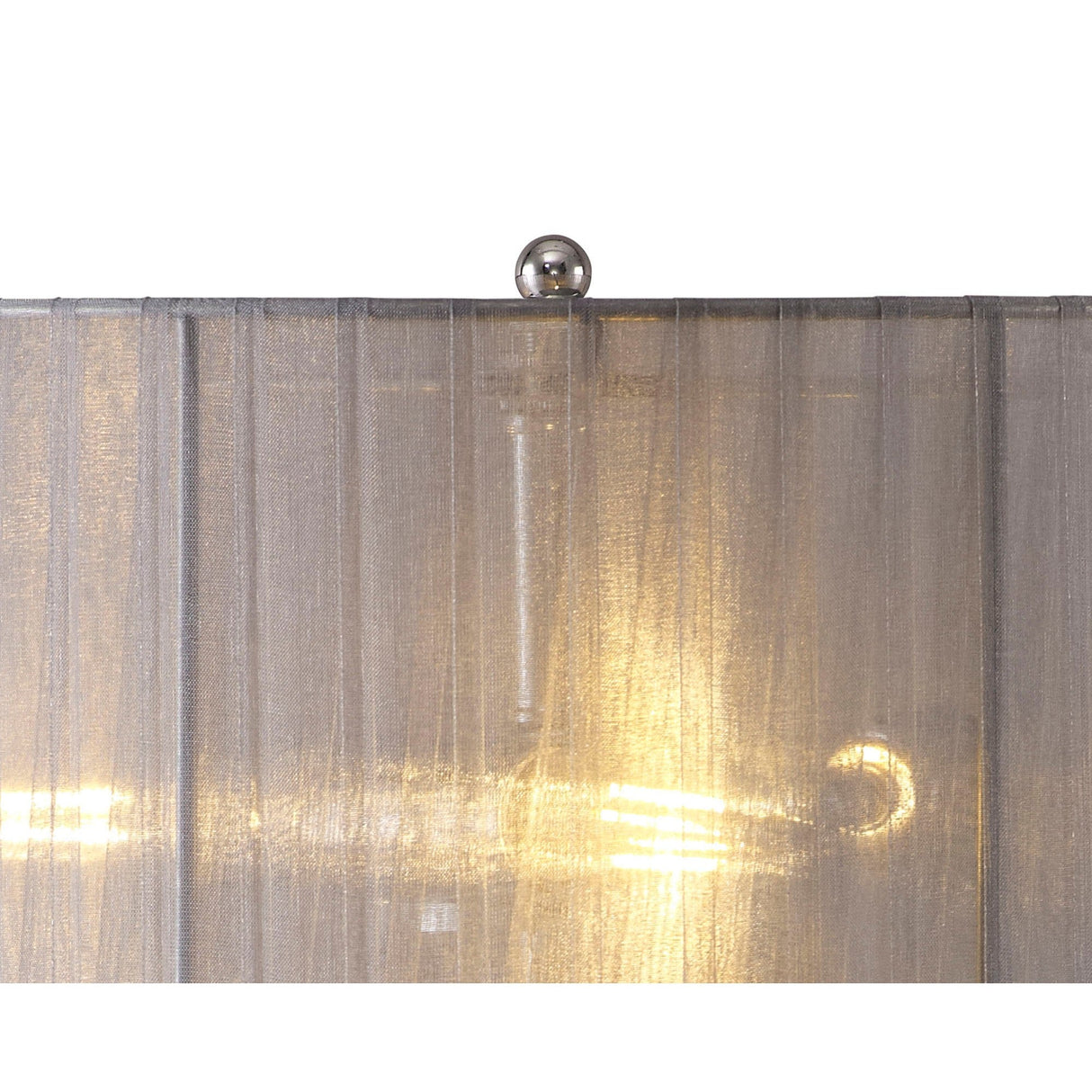 Close-up of the Freida 3 Light Crystal Table Lamp featuring polished chrome, a lit bulb shining through its grey organza shade, and an elegant chrome finial atop the translucent crystal design.