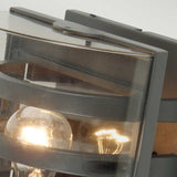The Frida Outdoor Wall Light - Graphite showcases a modern lighting design with a light bulb encased in a sleek, die-cast aluminium box, making it perfect for an outdoor wall light setup.