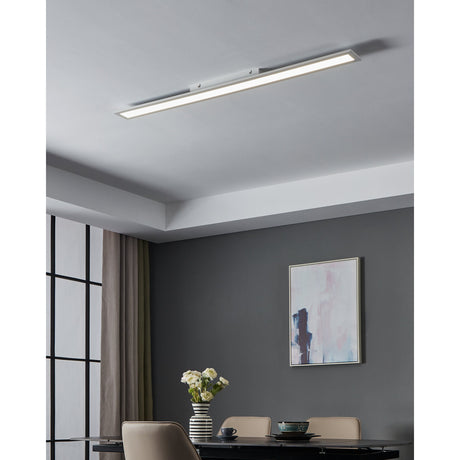 Frinarne LED Panel Light, a slim white rectangular ceiling fixture mounted flush on a grey ceiling in a dining room with a dark feature wall, framed artwork, and table setting below.