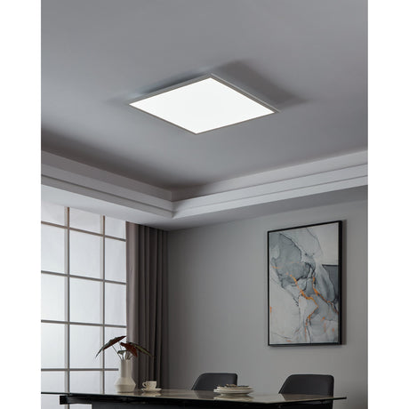 Frinarne LED Panel Light, a flush square ceiling fixture with white frame and diffuser, shown illuminated in a grey dining room ceiling recess above a table setting.