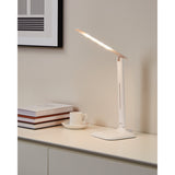 Frolmora LED touch table lamp in white, folding flat bar head on a slim steel and plastic stem with square base, shown lit on a sideboard beside books and a cup.