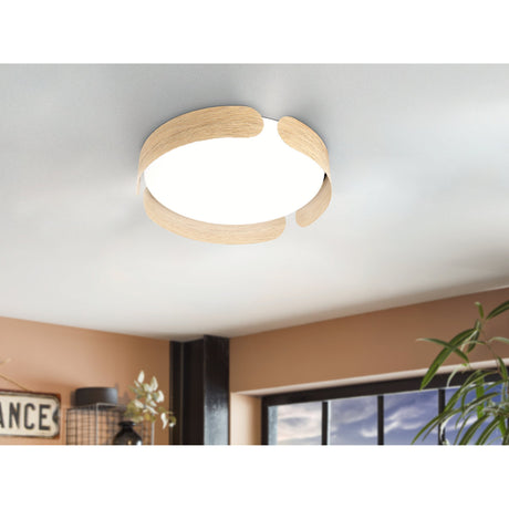 Frosmarne LED flush ceiling light with steel body, light oak-effect curved bands and white diffuser, fitted in a ceiling installation above a living room.