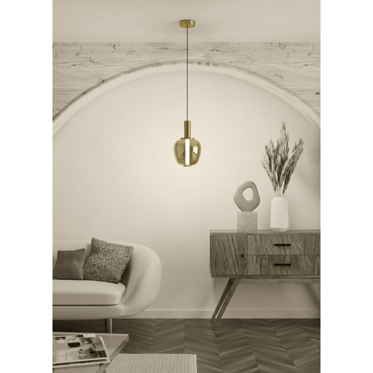 Fruitera Glass Pendant Light 21cm in brushed brass with an apple-shaped amber glass shade, hanging above a wooden sideboard in a neutral living room setting.