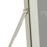 Close-up of the silver photo frame's hinged strut stand and white mount edge, shown against a plain white background.