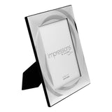 Rectangular silverplated photo frame with two-tone swirl pattern around the opening, easel back, holding a 7 x 5in print on a white background.