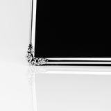 Close-up of a silverplate photo frame's corner, showing a slim polished silver border with a raised rose and leaf ornament, set against a plain white background.