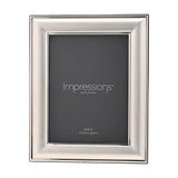 Silverplated rectangular metal photo frame with a broad satin silver band and polished edge lines, holding an 8 x 6in photo, shown on a plain white background.