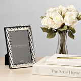 Silverplated swirl textured 4x6in photo frame with black stand on a wooden surface, styled with white roses and books in a living room setting.