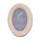 Oval photo frame with cream faux shagreen texture, silver-plated beaded edging, and a 2x3in opening, shown on a plain white background.