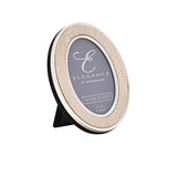 Oval photo frame with cream faux shagreen texture and silver beaded edging, black velvet back and stand, on a white background.