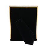 Rectangular photo frame in brown tortoiseshell-effect with gold-tone metal edges and inner border, shown with its black velvet rear stand, on a white background.