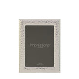 Rectangular freestanding photo frame with a textured, hammered silverplate border and smooth bevelled edge, holding a 5x7in print, shown on a plain white background.