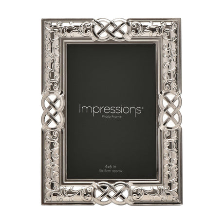 Rectangular silver metal photo frame with Celtic knot and scrollwork border, holding a 4x6in print, shown on a white background.