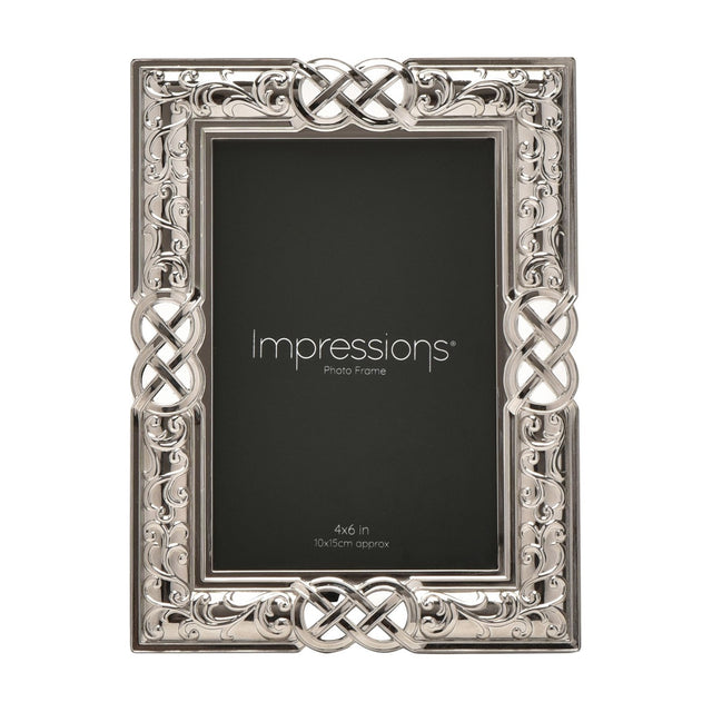 Rectangular silver metal photo frame with Celtic knot and scrollwork border, holding a 4x6in print, shown on a white background.
