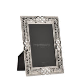 Rectangular silver metal photo frame with Celtic knot and scrollwork border, holding a 4 x 6in print, shown upright on a plain white background.
