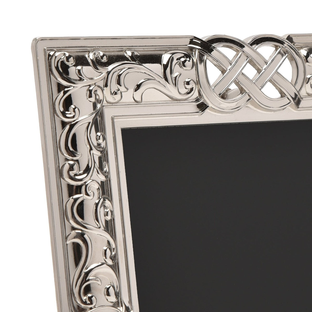 Close-up of the Celtic Knot Design Shiny Metal Photo Frame, 6 x 4in, showing silver scrollwork and interlaced knot detail on the corner, with black mat and plain white background.
