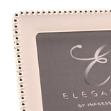 Close-up of a rectangular photo frame corner with a soft white epoxy border and silverplated metal beaded edge detailing.