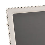 Close-up of a rectangular photo frame corner with soft white epoxy border and silverplated metal beaded edge detail, shown against a plain background.